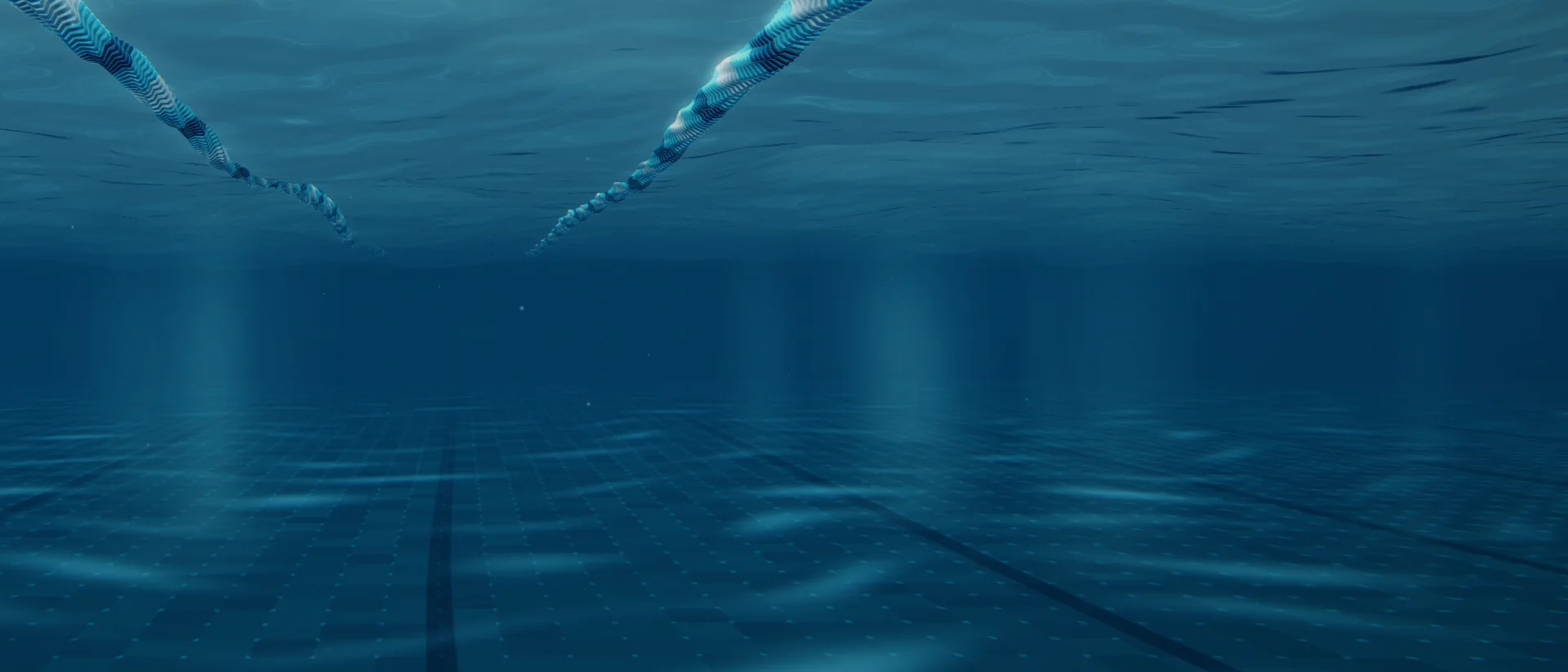 A close underwater view of the pool: the ends of two lane ropes, light rays through the water and a tiled floor with lane markings