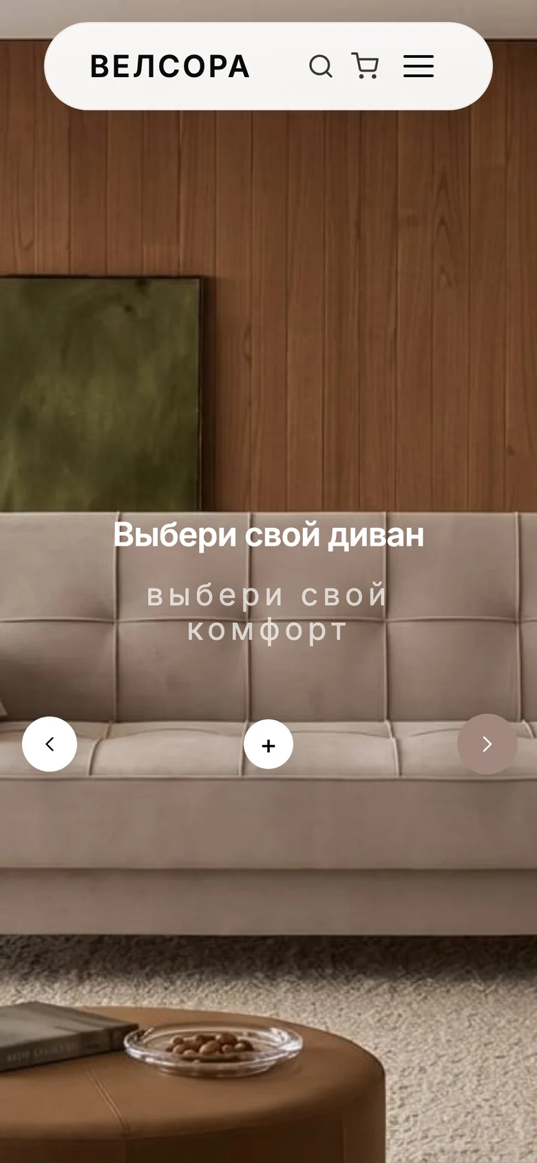 Главная Велсоры на телефоне: «Выбери свой диван, выбери свой комфорт» на интерьере со светлым диваном у деревянной стены, стрелки и плюс